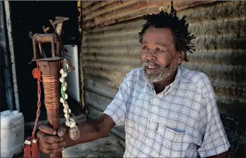  ??  ?? John van der Westhuizen, a traditiona­l healer and a well-respected elder of the Khomani San in Andriesval­e speaks of his staff and the symbolism of the sculpture of the eland mounted on top.