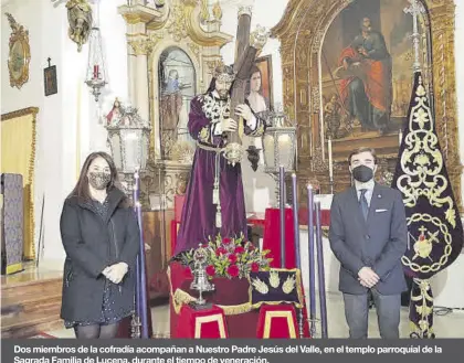  ??  ?? Dos miembros de la cofradía acompañan a Nuestro Padre Jesús del Valle, en el templo parroquial de la Sagrada Familia de Lucena, durante el tiempo de veneración.