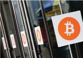  ??  ?? NEW YORK: In this file photo, Bitcoin logos are displayed at the Inside Bitcoins conference and trade show in New York. —AP