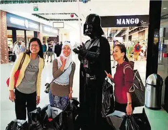  ?? Supplied picture ?? The force is strong with these ones Shoppers pose with a cut-out of Darth Vader, a major Star Wars character. The film is one of the top three anticipate­d films for teenagers this year, according to US bank Piper Jaffray.