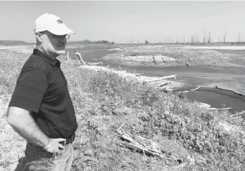  ?? GRANT SCHULTE/AP ?? Todd Bridges, a research scientist for the U.S. Army Corps of Engineers, stands July 26 along a new wetland area flooded in 2019, a few miles south of Rock Port, Missouri. The wetland is part of the Corps’ Engineerin­g with Nature initiative.