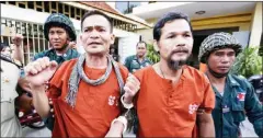  ?? PHA LINA ?? CNRP activists Ouk Pich Samnang (left) and Meach Sovannara (right) are escorted into the Supreme Court in February.