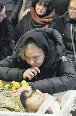  ?? Sergey Dolzhenko / Efe ?? Una mujer llora junto al cadáver de un soldado ucraniano, ayer en Kiev.