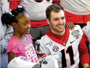  ??  ?? Alaysia Mitchell, 9, stands next to Georgia quarterbac­k Jake Fromm during a team photo with parents and patients at Ochsner Hospital for Children in New Orleans.