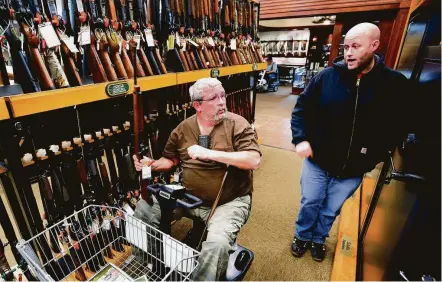  ?? Daniel Mears / Detroit News ?? Jerry Lyons, left, talks with Pat Ison at the Cabela's store in Dundee, Mich. Cabela’s still sells assault-style weapons.