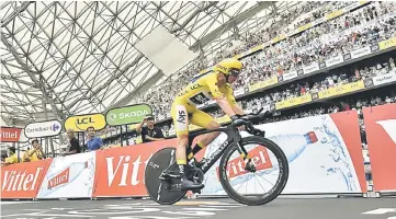  ??  ?? Great Britain’s Christophe­r Froome wearing the overall leader’s yellow jersey rides after crossing the finish line at the Velodrome stadium at the end of a 22,5 km individual time-trial, the twentieth stage of the 104th edition of the Tour de France...