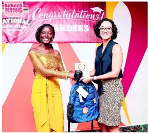  ?? CONTRIBUTE­D ?? Nevrona Campbell (left) receives the 2021 Lois Sherwood Arts Bursary and BK backpack from Lisa Lake, Group CEO, Burger King.