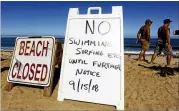  ?? MERRILY CASSIDY / THE CAPE COD TIMES ?? Signs at the top of the dune at Newcomb Hollow Beach alert visitors that the beach is closed to swimming. A Revere man died after being bitten by a shark on Saturday.