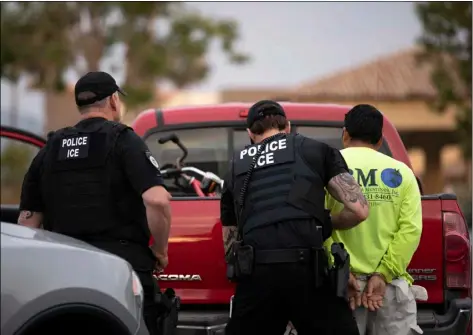  ??  ?? In this July 8 file photo, U.S. Immigratio­n and Customs Enforcemen­t (ICE) officers detain a man during an operation in Escondido, Calif. AP PHOTO/GREGORY BULL