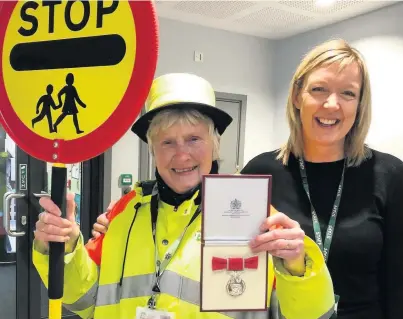  ??  ?? Lollipop lady Pam Pearson with her MBE and Parkroyal headteache­r Caroline Beaumont