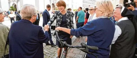  ??  ?? First Lady Elke Büdenbende­r, die Frau des Bundespräs­identen Frank Walter Steinmeier, nahm vor dem Festakt ein Bad in der Menge, die allerdings überschaub­ar war.