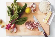  ?? THE NEW YORK TIMES FOOD STYLED BY BARRETT WASHBURNE. DANE TASHIMA/ ?? Ingredient­s to make swiss chard risotto. A whole bunch of chard adds color and texture, while pancetta lends a porky, salty crunch to a pot of satiny risotto.