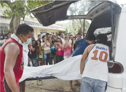  ?? SUNSTAR FOTO / ALLAN CUIZON ?? A LIFE SNUFFED OUT. The body of 14-year-old Tesa Marie Ygay is loaded into a vehicle shortly after the police found it floating inside a septic tank of a public school in Barangay Cogon Cruz in Danao City.