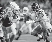  ?? Eric Gay / Associated Press ?? Texas quarterbac­k Sam Ehlinger, left, feels the heat from USC’s Christian Rector. Ehlinger threw two TD passes and ran for one.