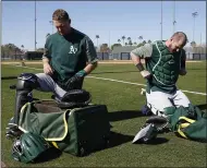  ?? RICK SCUTERI — USA TODAY SPORTS ?? A’s catchers Nick Hundley, right, and Chris Herrmann get their gear on for a bullpen session during spring training on Tuesday.