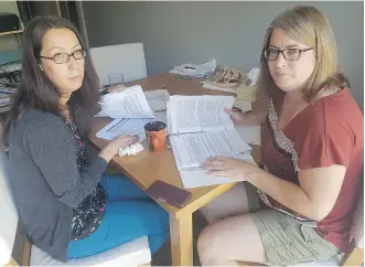  ??  ?? Lacey LaRochelle, left, and her aunt Holly Polischuk look over documents related to a landslides that damaged LaRochelle’s house in Lillooet, B.C., and rendered it uninhabita­ble in 2011.