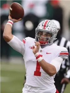  ?? GETTy ImAgES ?? ONE MORE GAME: Ohio State quarterbac­k Justin Fields throws a first-half touchdown pass against Michigan State on Saturday in East Lansing, Mich.