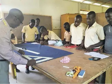  ?? BY RUSS COLLINS ?? Trinity Church’s Russ Collins and Mary Frances leMat visit a tailoring class at the St. Marc Trade School in Trouin, Haiti, a school the church helps sponsor.