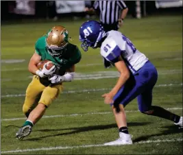  ??  ?? YUMA CATHOLIC JUNIOR running back Ean Chavez lowers his shoulder as he tries to run over Safford cornerback Bryant Montoya in the second quarter of a 65-28 win Friday night at Ricky Gwynn Stadium.