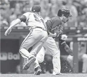  ?? JEFF HANISCH / USA TODAY SPORTS ?? Brewers second baseman Keston Hiura is tagged out between third base and home by Atlanta Braves pitcher Max Fried in the fifth inning while trying to score Monday night