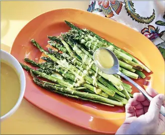  ?? The Associated Press ?? Roasted asparagus with lemon dressing is pictured. This lemon sauce is a simple way to dress up roasted asparagus, the pinup vegetable of spring.