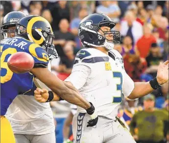  ?? Wally Skalij Los Angeles Times ?? RAMS EDGE RUSHER Dante Fowler causes Seattle’s Russell Wilson to fumble during a sack in the fourth quarter. The Rams converted the turnover into a nine-yard touchdown run by Brandin Cooks.