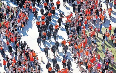  ?? [SARAH PHIPPS/ THE OKLAHOMAN] ?? In pre-socially distanced times, fans cheer as OSU football players walk in to Boone Pickens Stadium last season before facing Baylor.