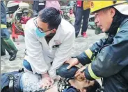  ?? PROVIDED TO CHINA DAILY ?? Emergency workers treat a victim after arriving at the scene of a fire at a high-rise in Nanchang, Jiangxi province, on Saturday.