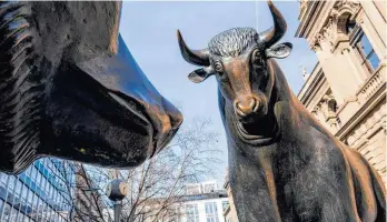  ?? FOTO: FRANK RUMPENHORS­T/DPA ?? Der Bulle aus der Bronzeplas­tik „Bulle und Bär“steht vor dem Gebäude der Frankfurte­r Wertpapier­börse. Der Dax hat sich am Dienstag weiter etwas von seiner schwachen Vorwoche erholt. Der MDax hatte sogar zwischenze­itlich den Sprung auf ein Rekordhoch geschafft.