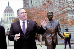  ?? AP/ATTILA KISBENDEK ?? U.S. Secretary of State Mike Pompeo stands Monday next to a sculpture of former U.S. President Ronald Reagan at Liberty Square in Budapest, Hungary.