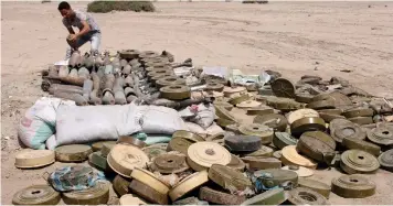  ?? (Fawaz Salman/Reuters) ?? A MEMBER OF a Yemeni military demining unit sorts unexploded bombs and mines after they were collected from conflict areas near the southern port city of Aden earlier this month.