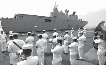  ?? ASSOCIATED PRESS ?? A Philippine Navy band plays to welcome the Royal Australian Navy HMAS Adelaide, an amphibious assault ship and landing helicopter dock, as it docks in the South Harbor for a five-day port call, in Manila.