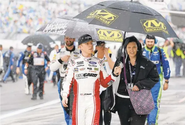  ?? AP ?? John Hunter Nemechek and rest of drivers head for shelter as rain delays Daytona 500 Sunday, eventually postponing race until this afternoon.