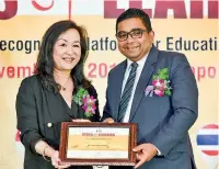  ??  ?? AIS: Mr. Perera receiving the Distinguis­hed Educationi­st Award from Prof. Christina Hong - President Technologi­cal and Higher Education Institute, Honkong