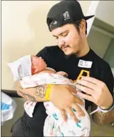  ?? COURTESY OF CHURCH FAMILY ?? Cody Church holds his newborn, Ryan James Tatis Church, in October.
