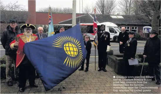  ?? Ormskirk town crier Don Evans and an Ormskirk Primary School pupil help veterans from the Skelmersda­le Ex-Services Associatio­n raise the Commonweal­th flag, watched by invited guests ??