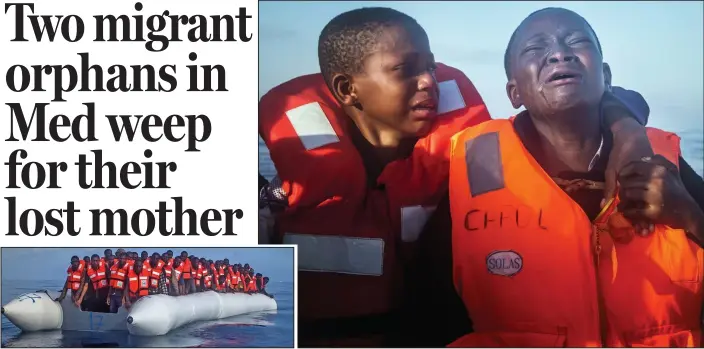  ??  ?? Danger: Desperate migrants, including two young children grieving for their mother, wait aboard an overcrowde­d rubber boat to be rescued in the Mediterran­ean Sea