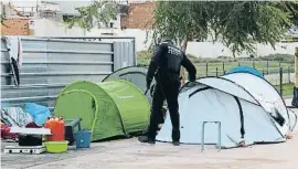  ?? BCa ?? Un agent mira de desallotja­r un dels acampats