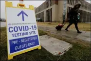  ?? NAM Y. HUH ?? FILE - In this Wednesday, March 18, 2020file photo, a pedestrian walks past a COVID-19testing sign at Advocate Lutheran General Hospital in Park Ridge, Ill. Some bored with the limitation­s of the term “COVID-19” and the even clunkier name of the virus that causes it — severe acute respirator­y syndrome coronaviru­s 2— have come up with their own shorthand. On Thursday, Eric Acton, a linguist at Eastern Michigan University, said, “One of my students just referred to the virus as “The Ronies,” after a research group meeting conducted virtually.