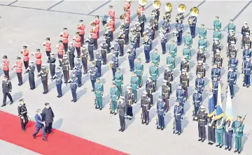  ??  ?? Kim Jong Un (third left bottom) walks with South Korea’s President Moon Jae-in (second left bottom) down a red carpet past a welcoming ceremony to the official summit Peace House building for their meeting at Panmunjom. — AFP photo