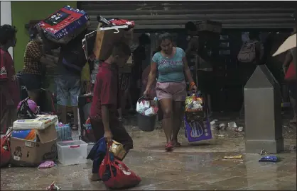  ?? PHOTOS BY MARCO UGARTE — THE ASSOCIATED PRESS ?? People loot a grocery store after Hurricane Otis ripped through Acapulco, Mexico, on Wednesday. The hurricane hit Mexico’s southern Pacific coast as a powerful Category 5storm, unleashing massive flooding, ravaging roads and leaving large swaths of the southweste­rn state of Guerrero without power or cellphone service.