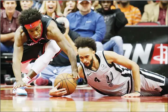  ??  ?? San Antonio Spurs guard Derrick White (4) and Houston Rockets forward Danuel House Jr chase a loose ball during the second half of an NBA basketball game, Dec 16, in Houston. (AP)