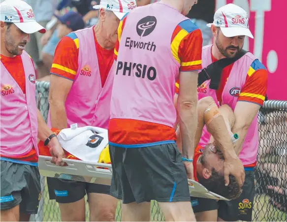  ??  ?? Sam Day is carried from the ground in agony after suffering an injury that was compared to that of a car crash victim. Picture: MIKE BATTERHAM