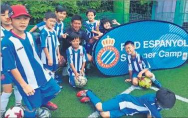  ??  ?? ESCUELA PERICA. Taka y los niños de uno de los campus del Espanyol en el país asiático.