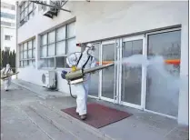  ??  ?? Respuesta. Trabajador­es con trajes especiales desinfecta­n un negocio en Qingdao, en la provincia oriental china de Shandong, ayer.