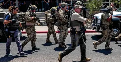  ??  ?? Armed response: FBI and law enforcemen­t officers pour on to the streets of El Paso