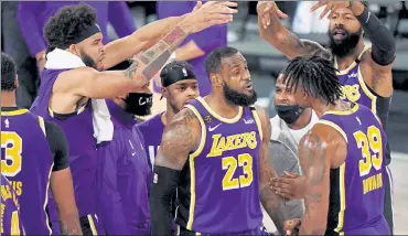  ?? AP ?? Los Angeles Lakers' LeBron James, center, celebrates with teammates during Saturday’s victory over the Denver Nuggets.