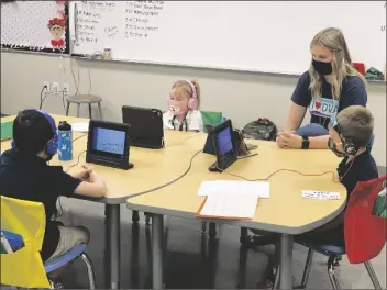  ??  ?? STUDENTS AT DESERT VIEW ACADEMY engage in distance learning while following the K-5 school’s face mask protocol.