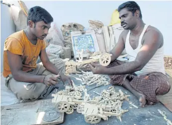  ??  ?? METICULOUS JOB: Indian craftsmen cut wood using a bandsaw at a workshop in Kondapalli village in Vijayawada district of Andhra Pradesh state.