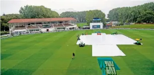 ?? AFP ?? The covers lay over the wicket as rain ruined the last day of the Test match. —